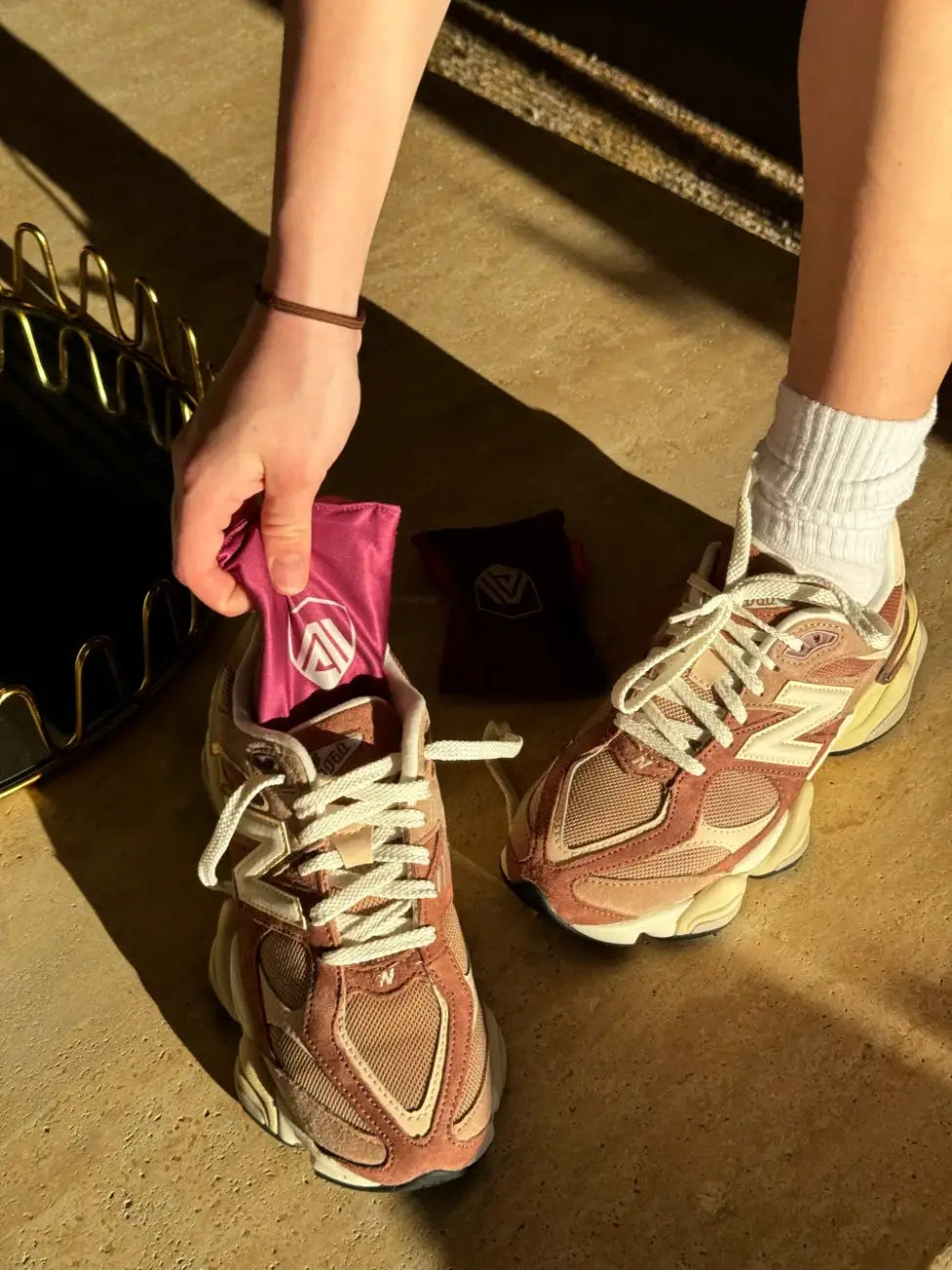 Sandalwood Aroma Armour Shoe Fresheners being taken out of New Balance 9060s during golden hour