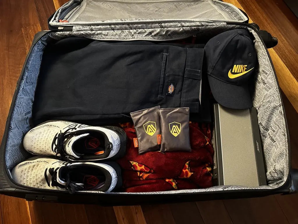 Zesty Lemon Aroma Armour Shoe Fresheners sitting on top of a packed suitcase and Ocean Breeze Aroma Armour Shoe Fresheners sitting inside shoes packed in the suitcase